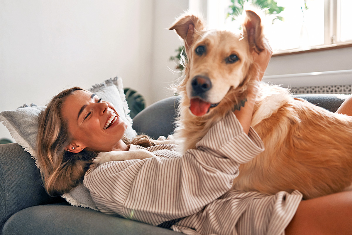 pet parent cuddles with dog on the couch