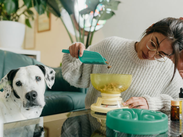 Woman measuring dog food with scale 