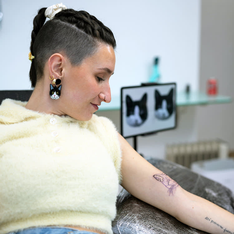 Woman getting a tattoo of her pet cat.