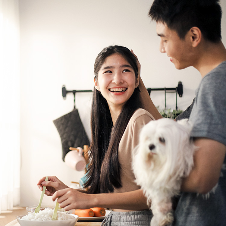 Couple making dinner in the kitchen with their dog.