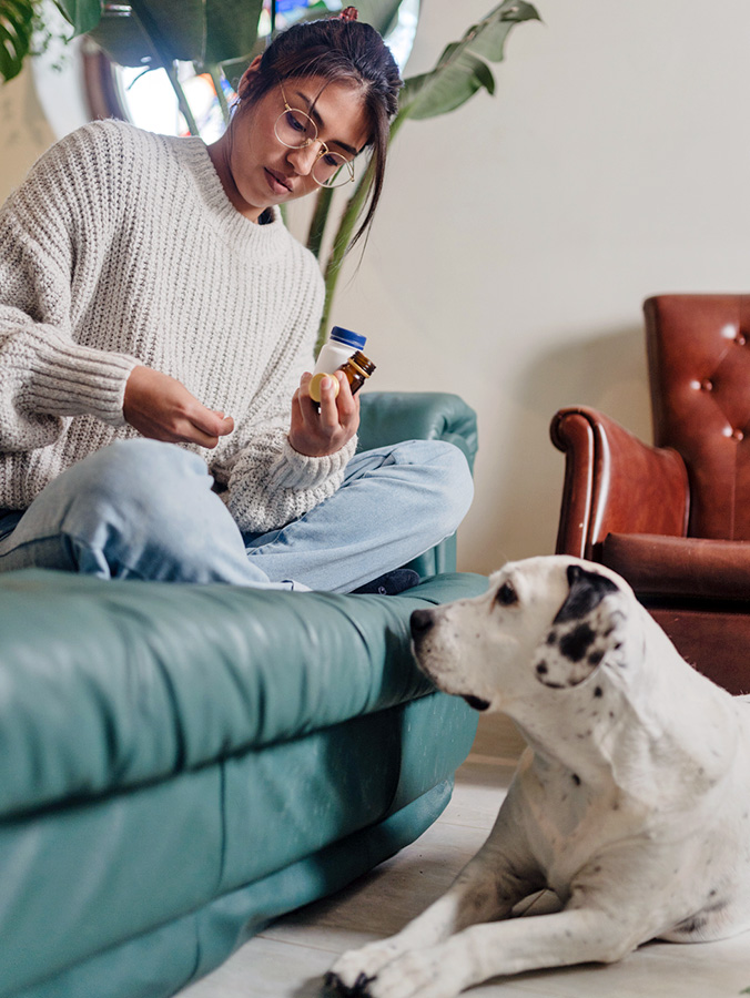 Woman giving her dog some medicine.
