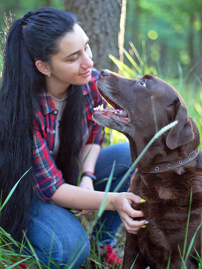 Woman with her senior dog outside in the forrest.