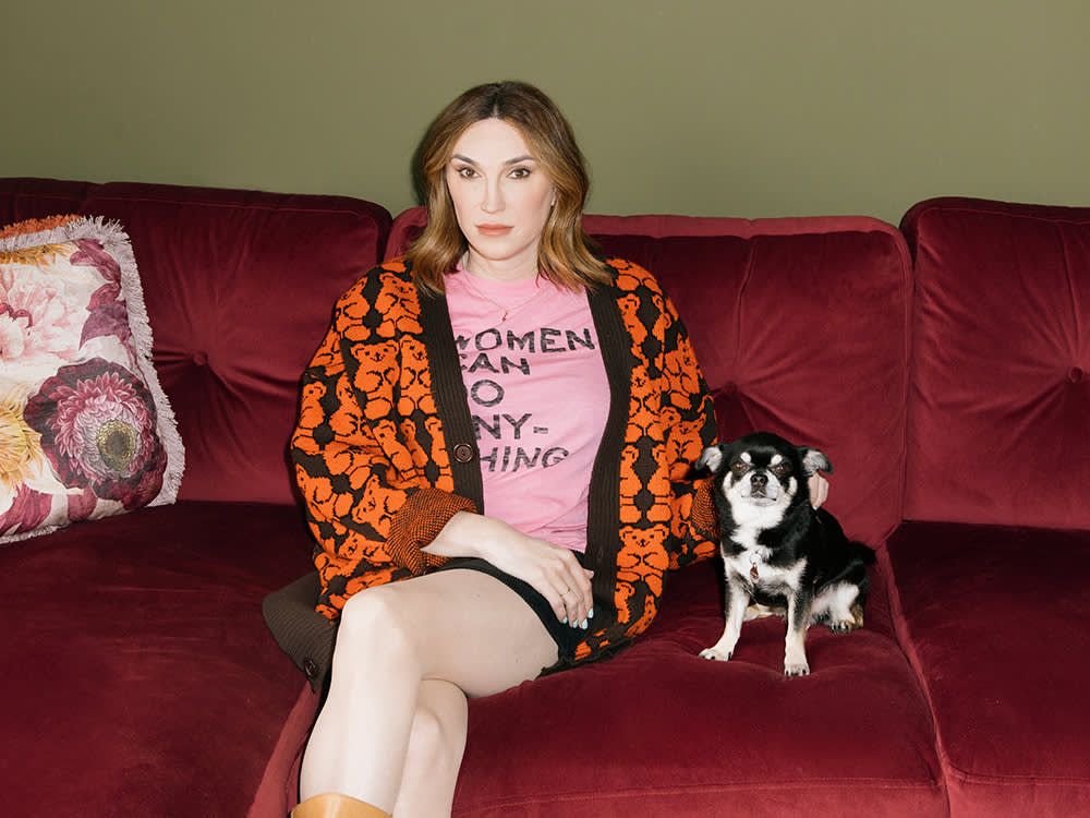 Juno Dawson on a red couch with her Chihuahua, Prince