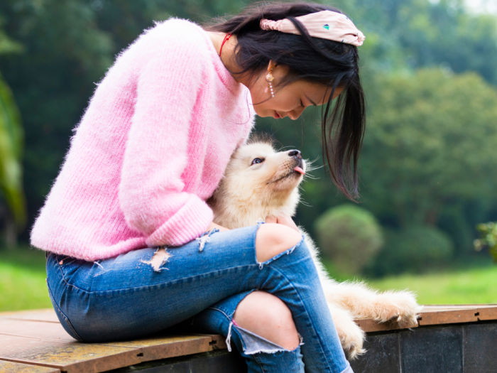 Woman sitting with her dog outdoors