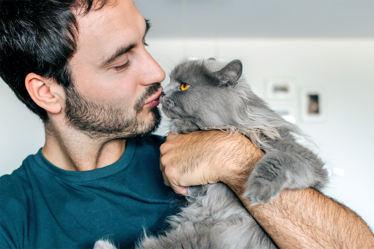 person kissing cat