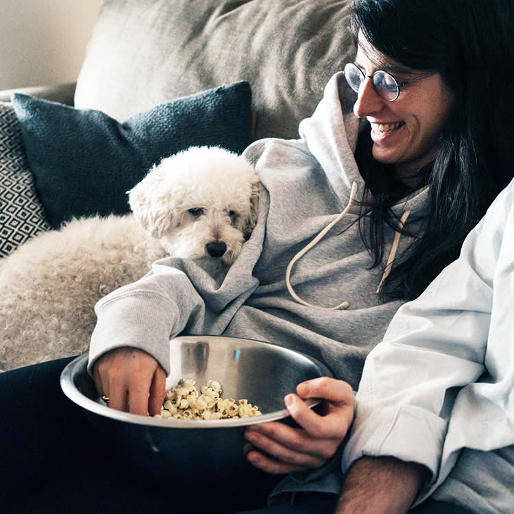 dog sitting by a bowl of popcorn