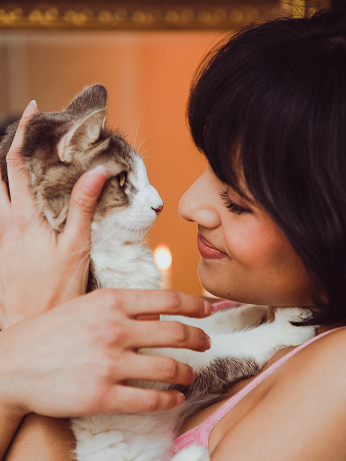 Aparna Brielle holding her cat close to her face