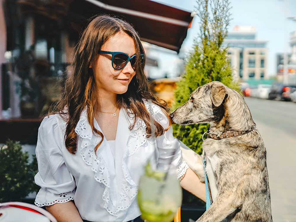 Woman outside at a cafe with her dog.