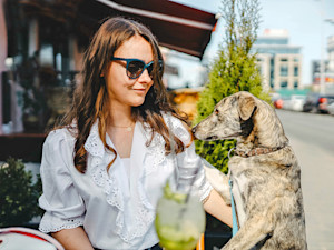 Woman outside at a cafe with her dog.