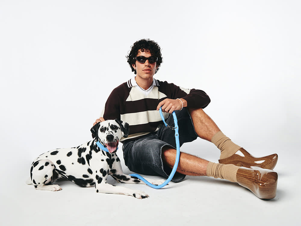 Lunge petcare, a person sitting with a large black and white dog with a blue leash 