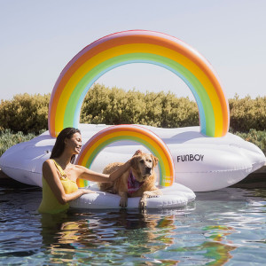 Woman and her dog in the Rainbow Cloud Daybed Pool Float by Funboy and BARK.