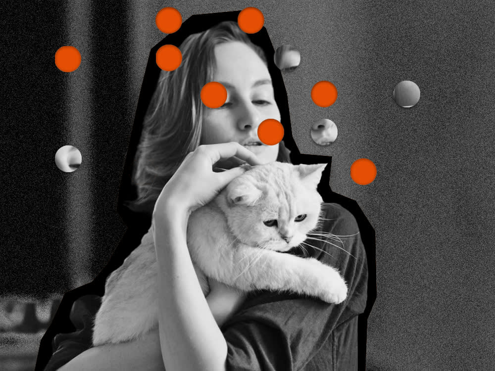 A woman tries to snuggle a reluctant cat