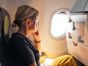 Worried young woman sitting on plane.