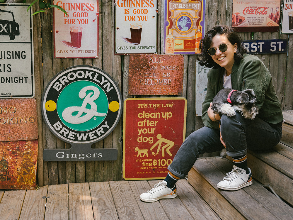 Erica Rose and Patty pose in front of outdoor Guinness and other bar signs at Ginger’s Bar.