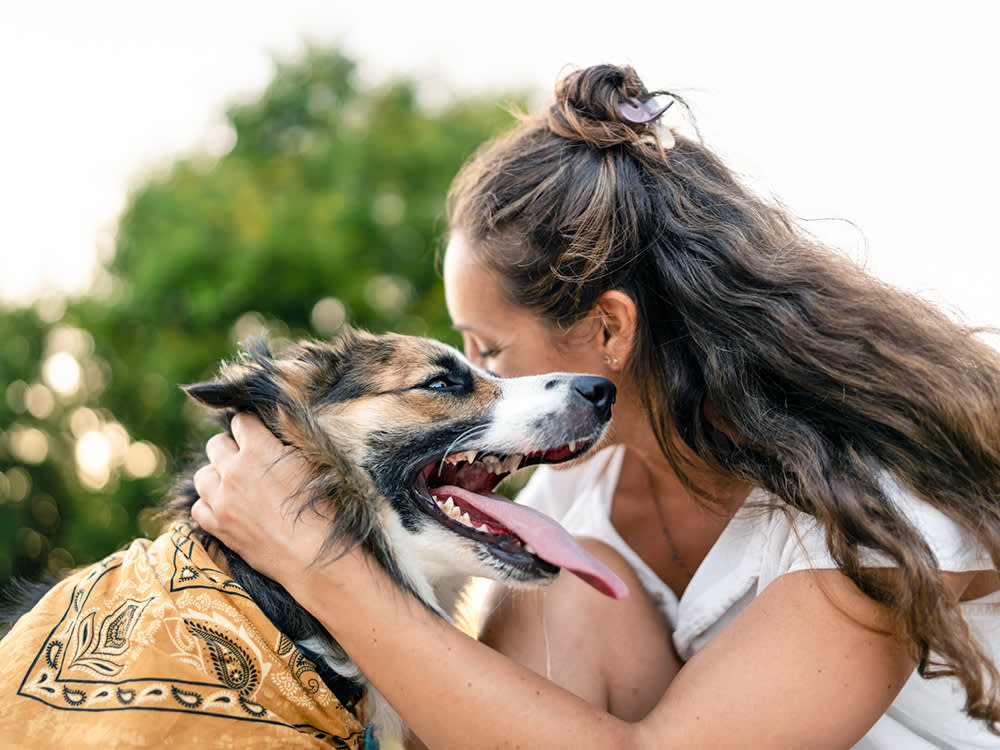 Woman hugging her dog outside.
