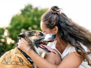 Woman hugging her dog outside.