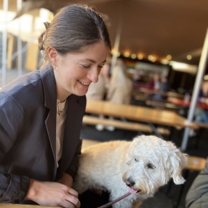 a smiling woman with brown hair with a white dog