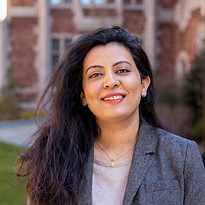 headshot of a smiling woman with long hair wearing a suit}}