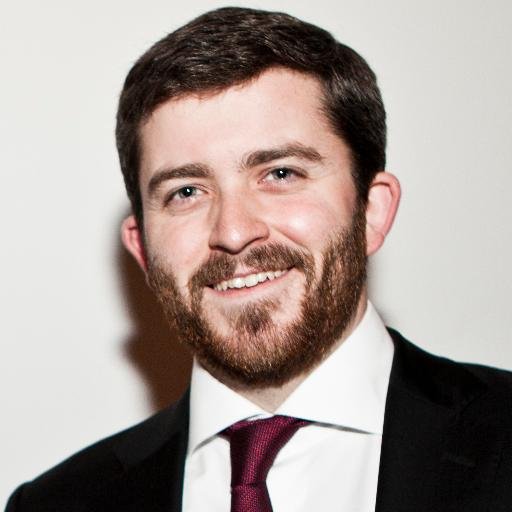 Head shot of Nick Shockey, a young white man in a suit with a beard.}}