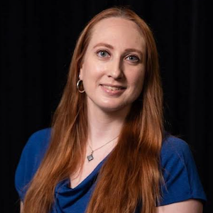 Formal headshot of a young white woman with long hair smiling at the camera.}}
