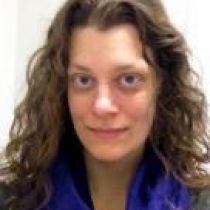 woman with curly hair smiling at the camera}}