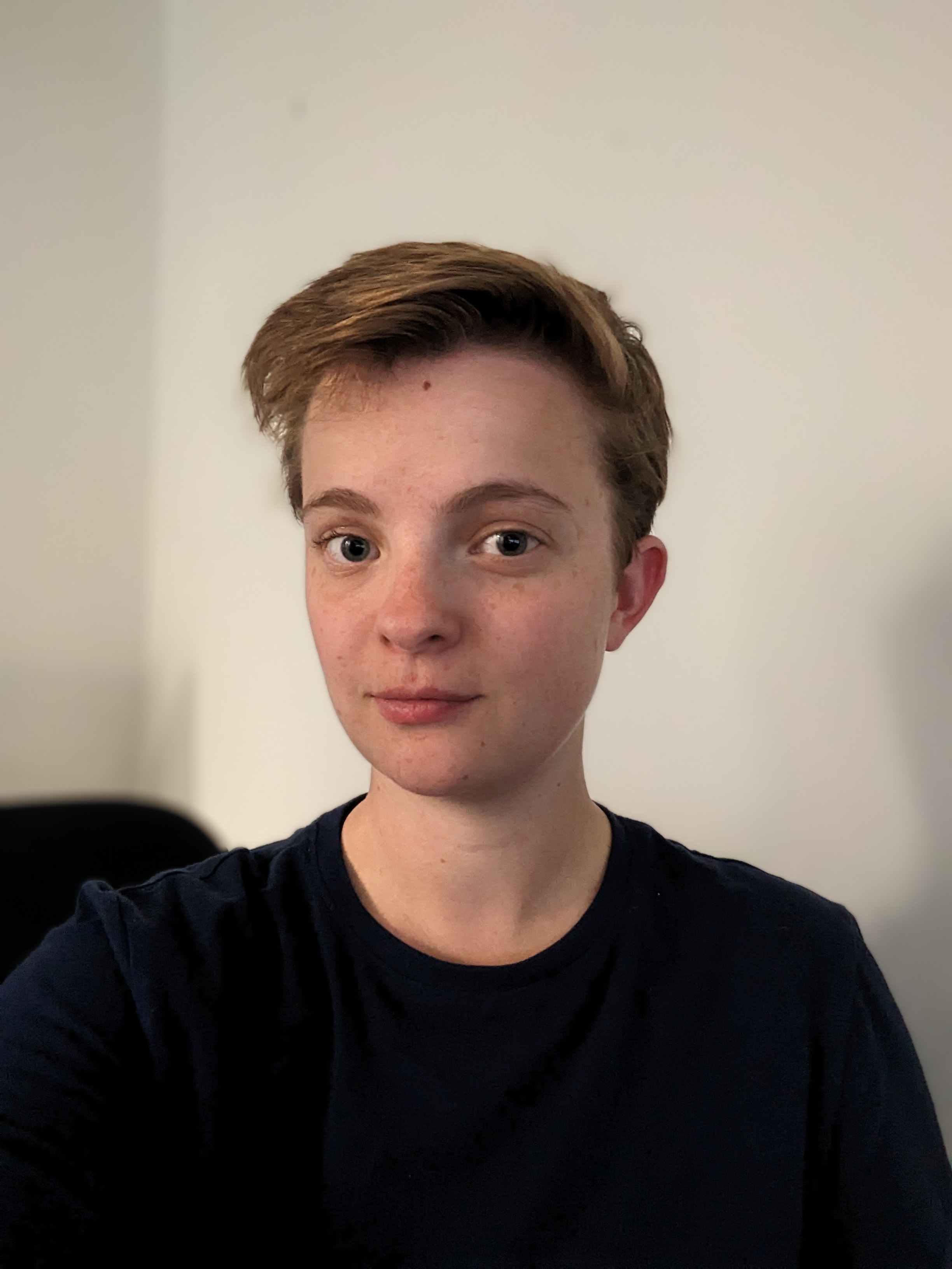 casual headshot of young person with short hair dressed in black}}