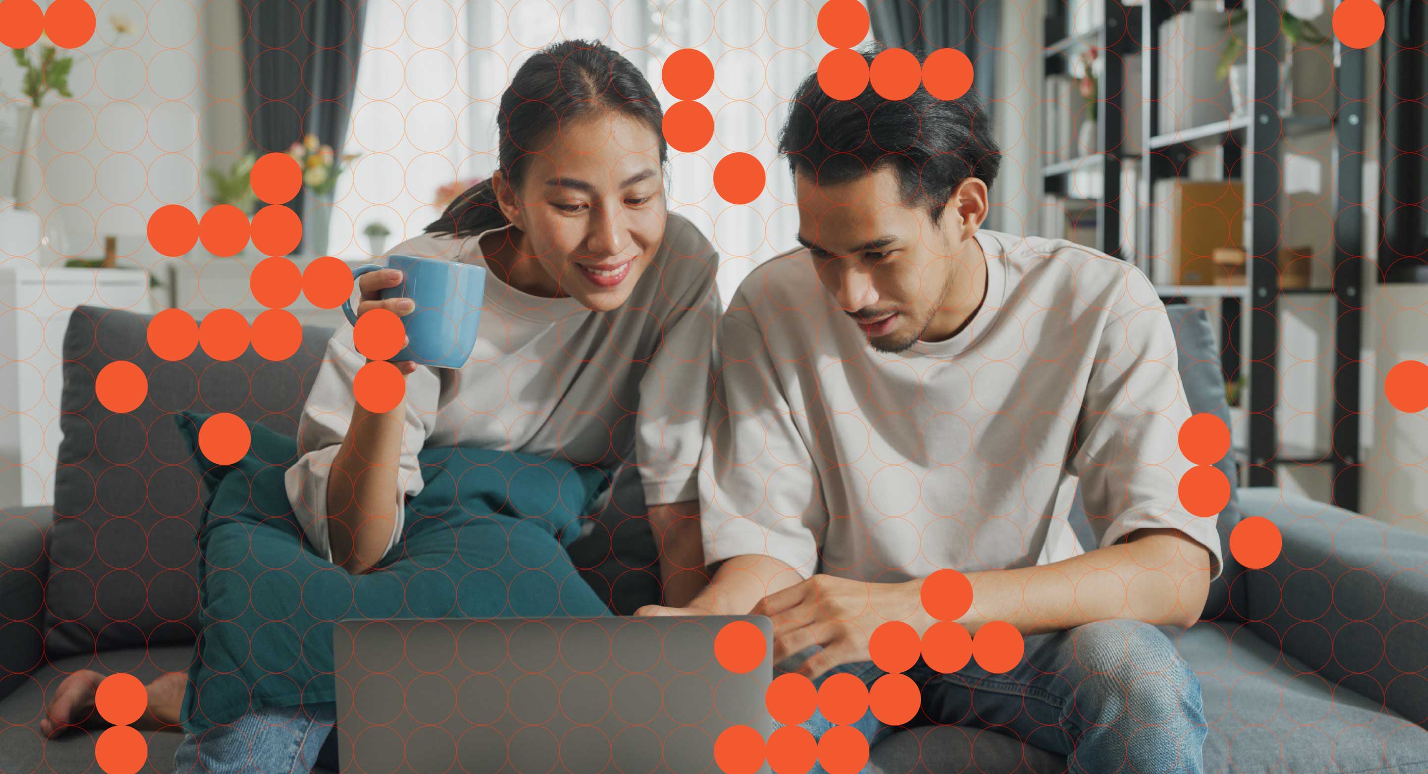 Two people sit at a computer evaluating something on the screen.