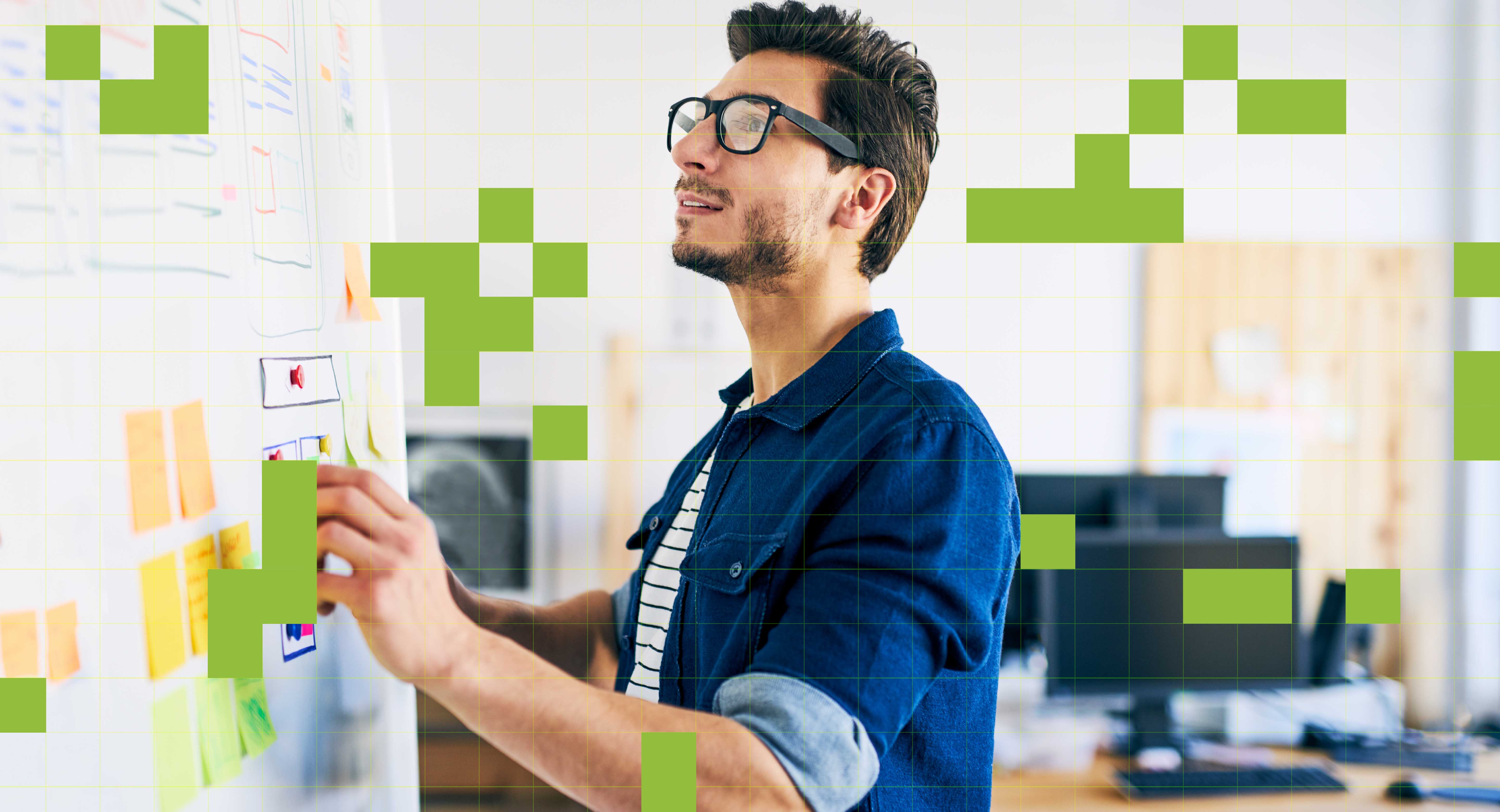 A man works at a white board with sticky notes