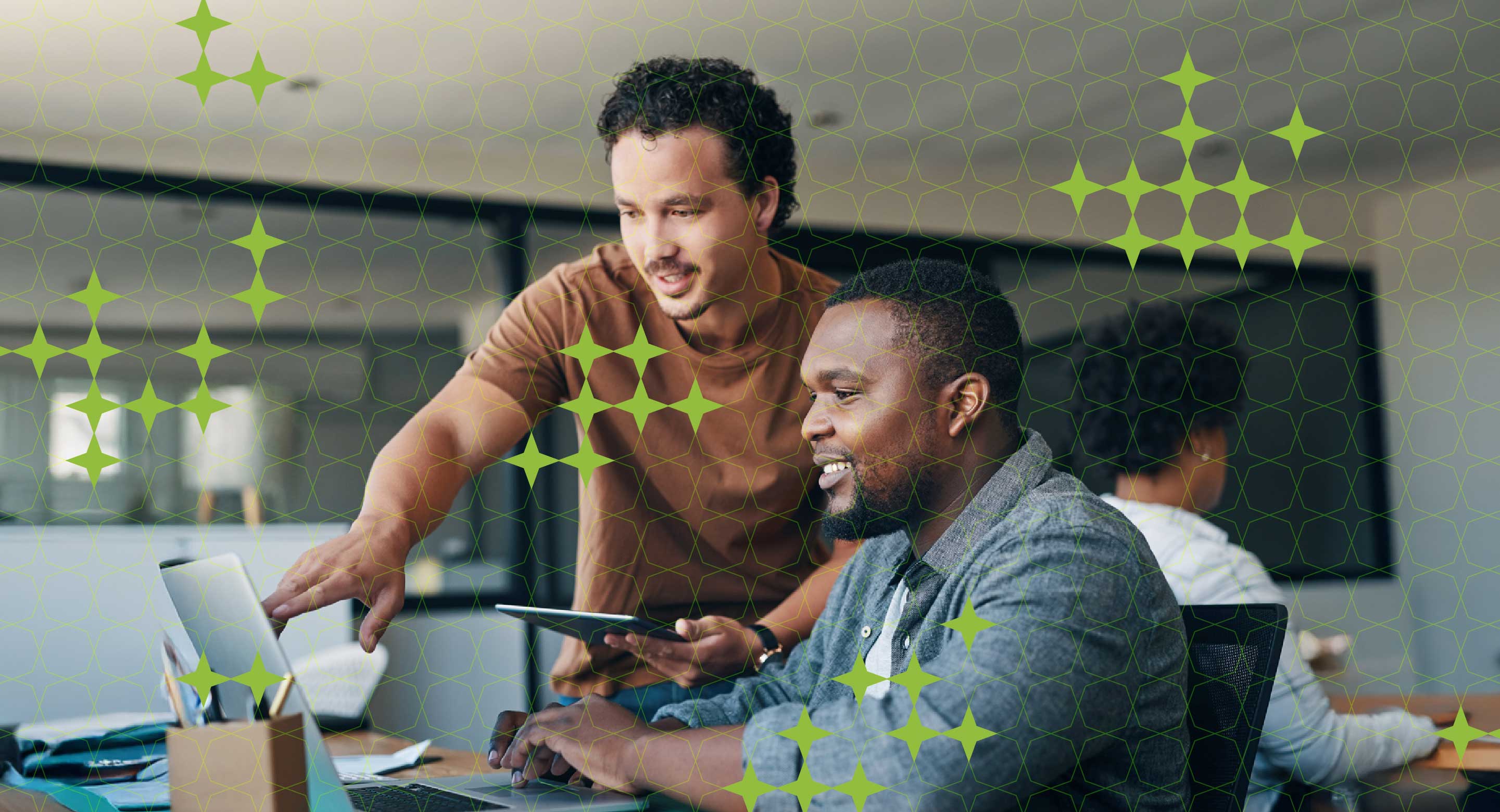 Two men discuss work on a laptop.