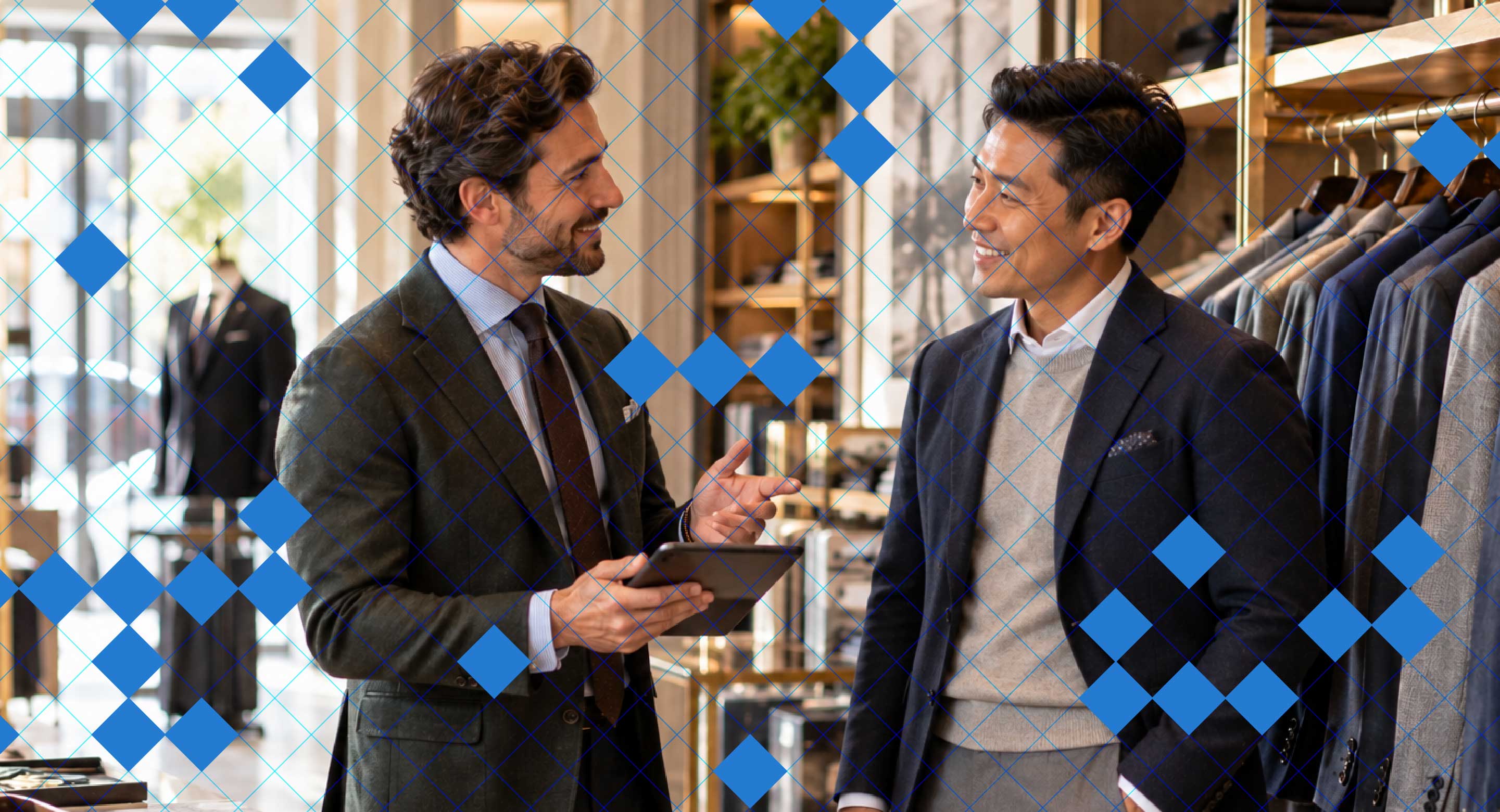 Two men in a store discuss something, one holds a tablet.