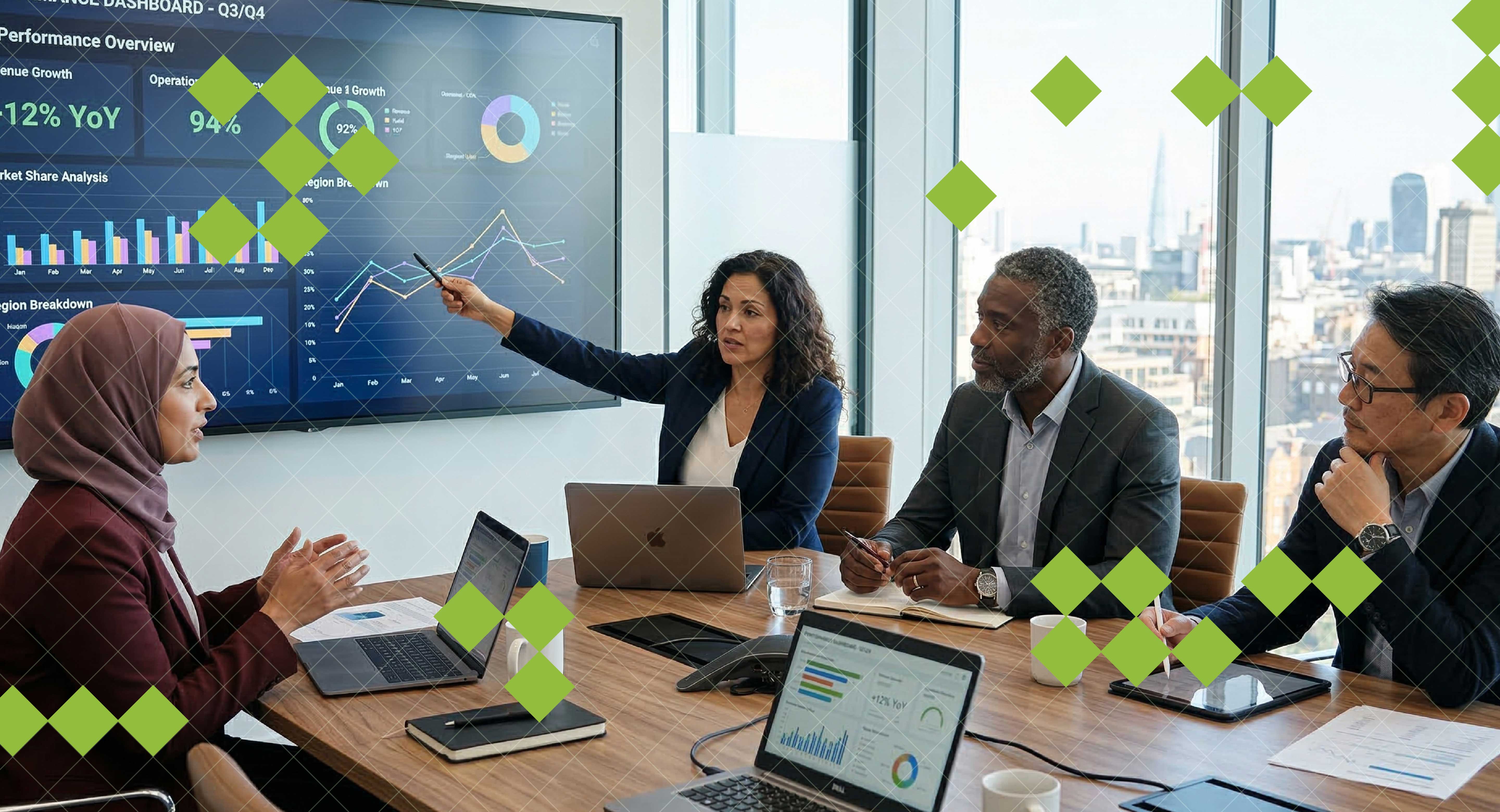A team sits around a boardroom table discussing data displayed on a screen at the front of the room.