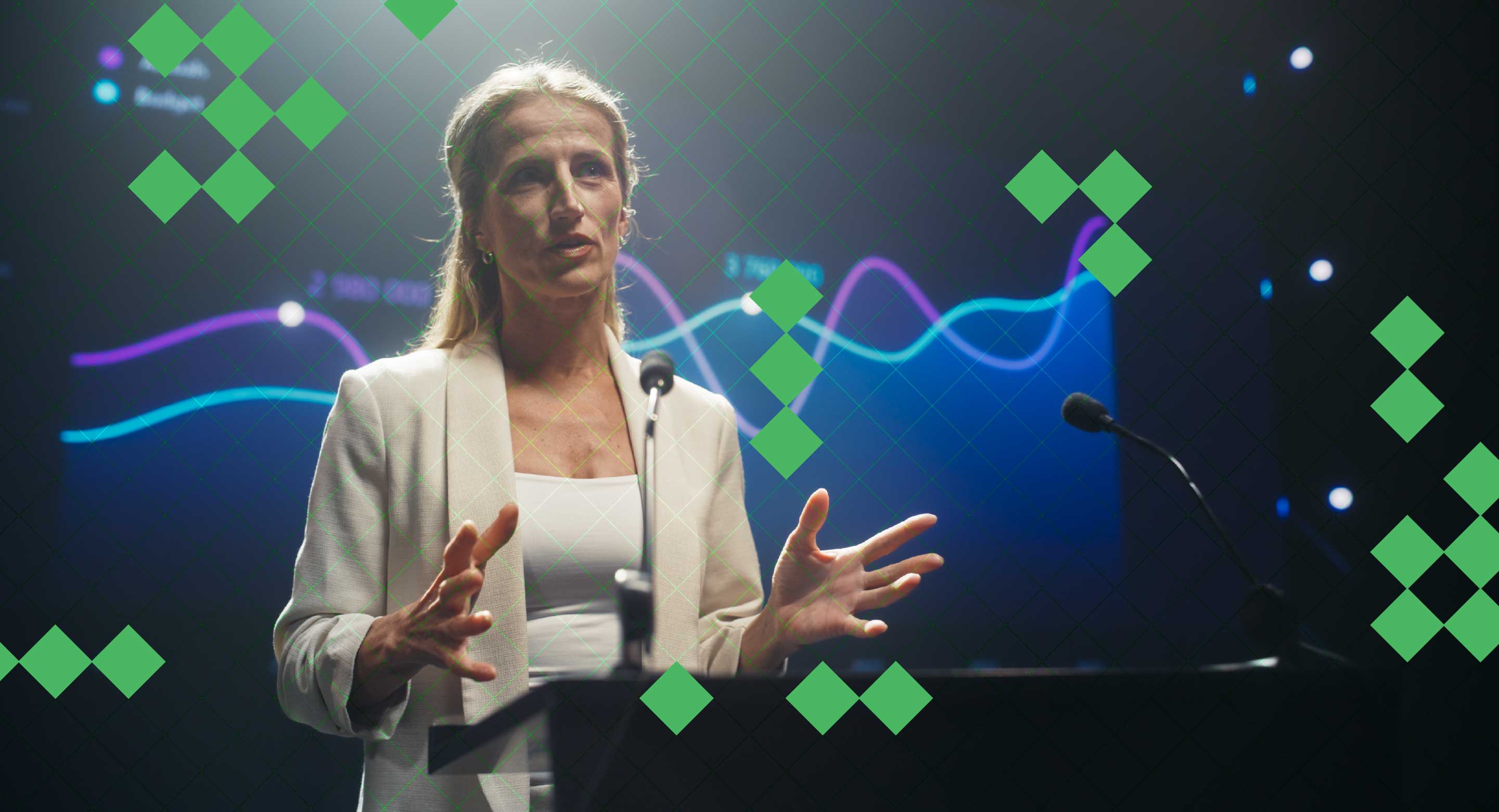 A woman presenting at a podium in front of a screen with a chart on it
