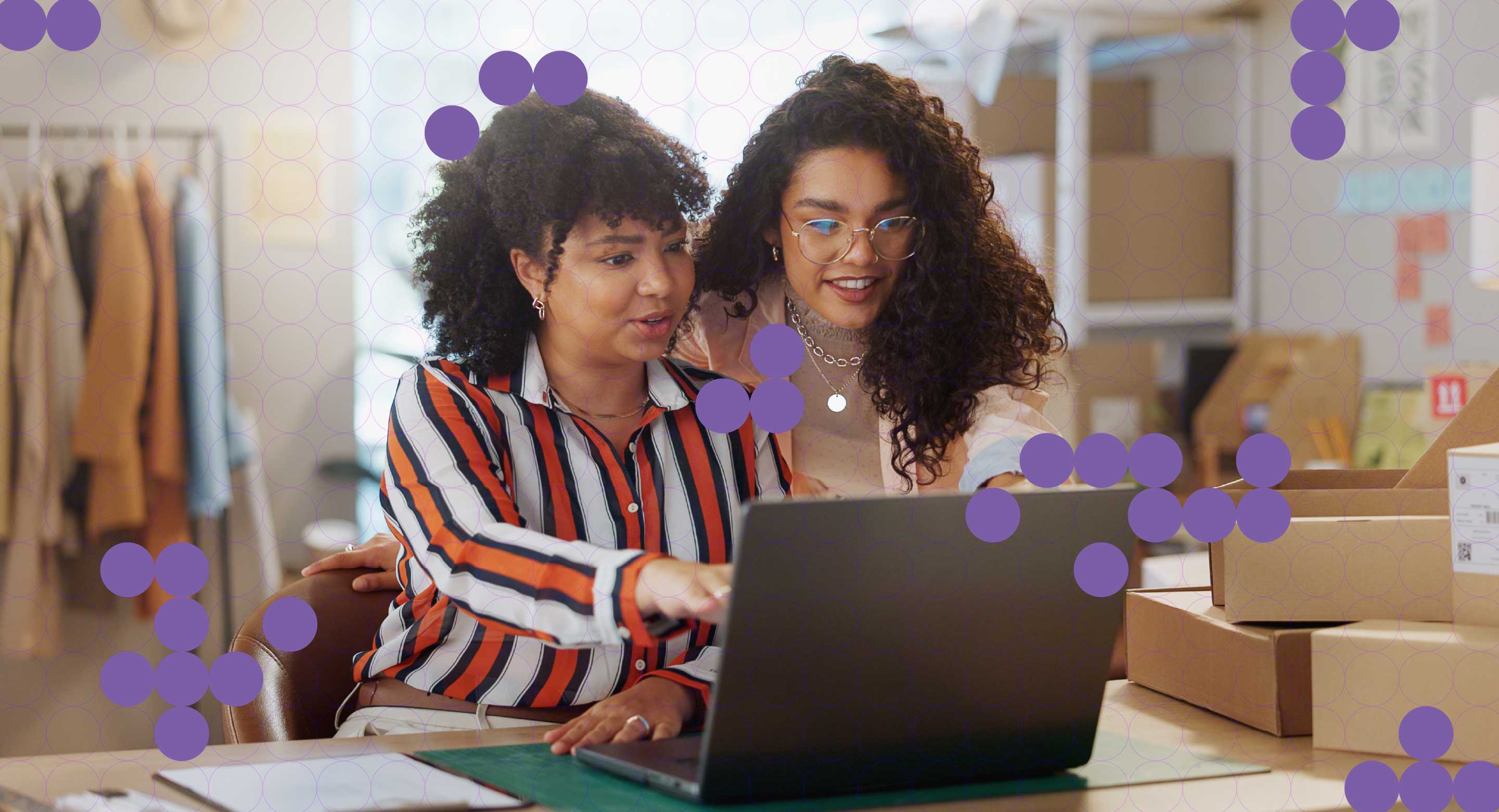 Two team members in a retail office space look at information on a computer screen