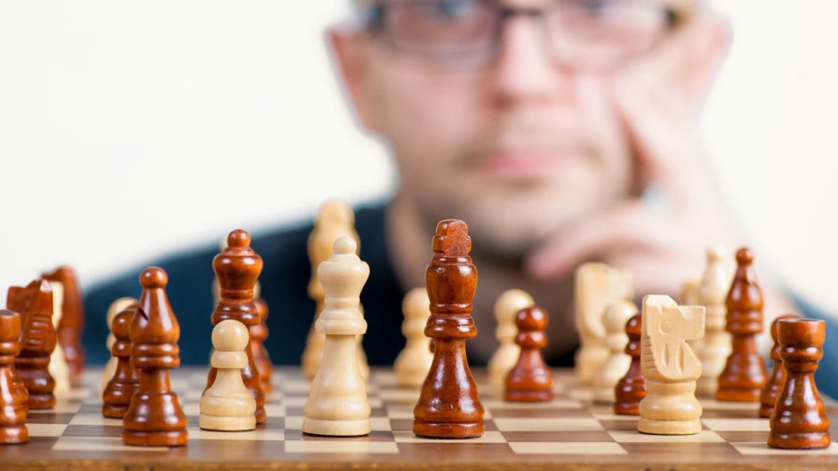 Chess board, with man's face blurred in the background