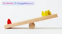 People-shaped blocks on a wooden seesaw