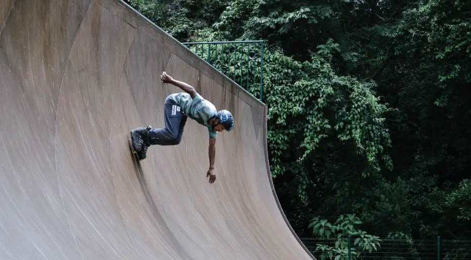 Man rollerblading down a skate ramp