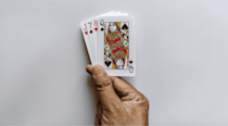 Hand holding four playing cards