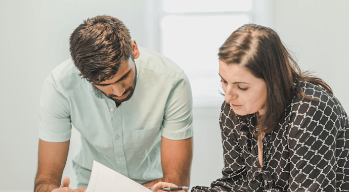 Man and woman standing together looking over some papers