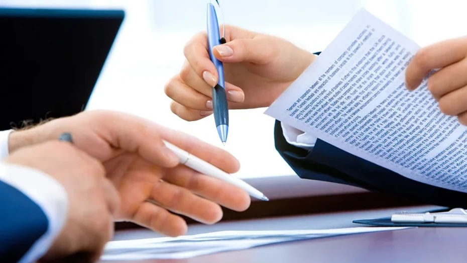 Hands holding pen and legal document