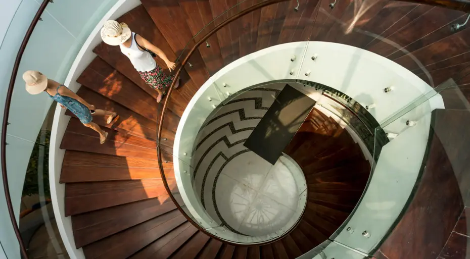 Two women walking down a spiral staircase