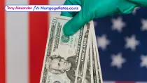 Glove holding American $20 bills in front of USA flag
