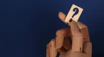 Wooden mannequin holding a question mark