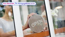 Woman holding 'open' sign in shop window