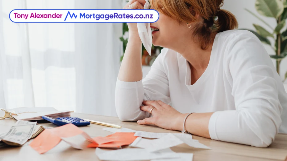 Woman crying, calculator and money on table