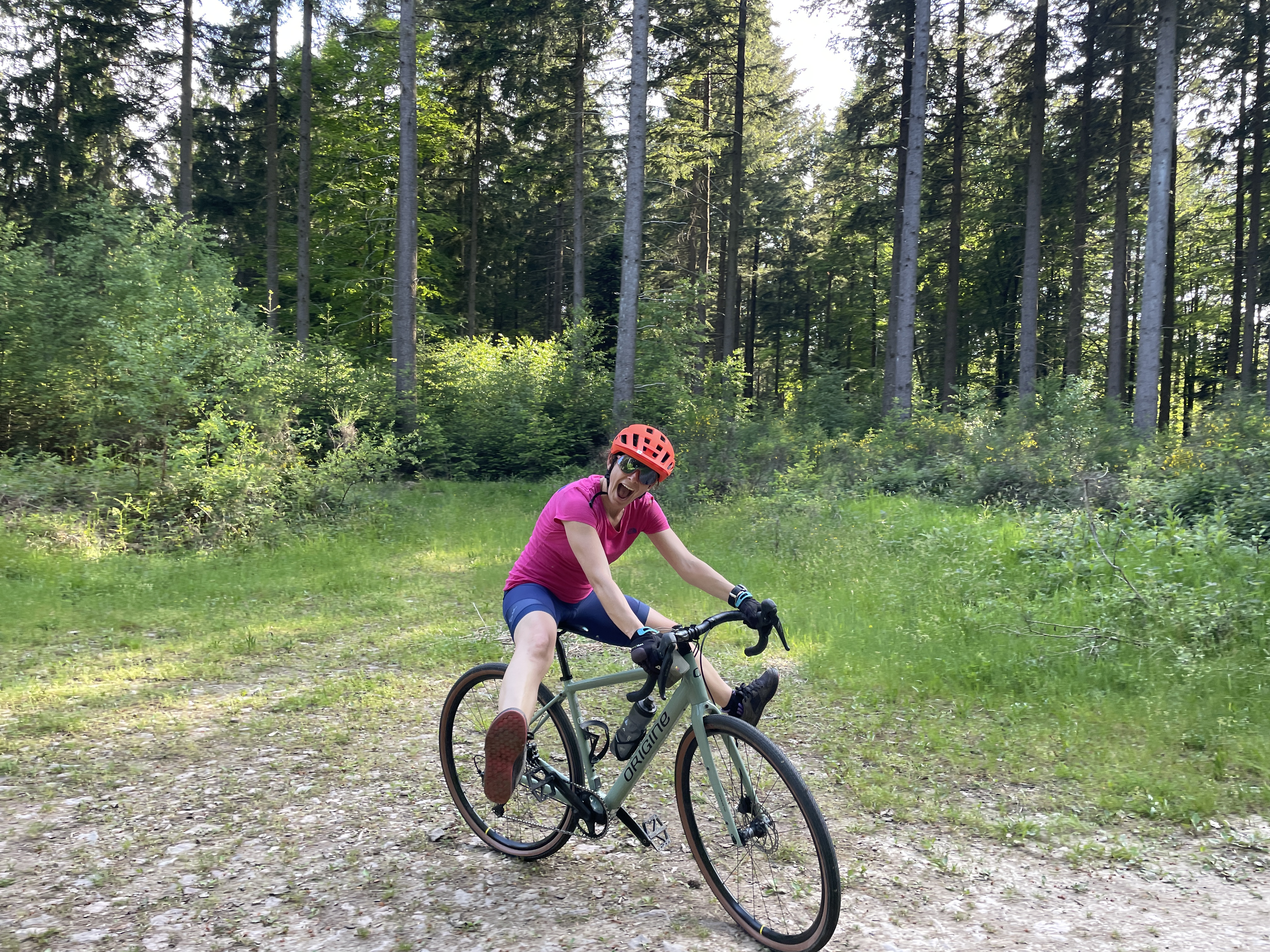 une femme en tain de rigoler sur un vélo gravel