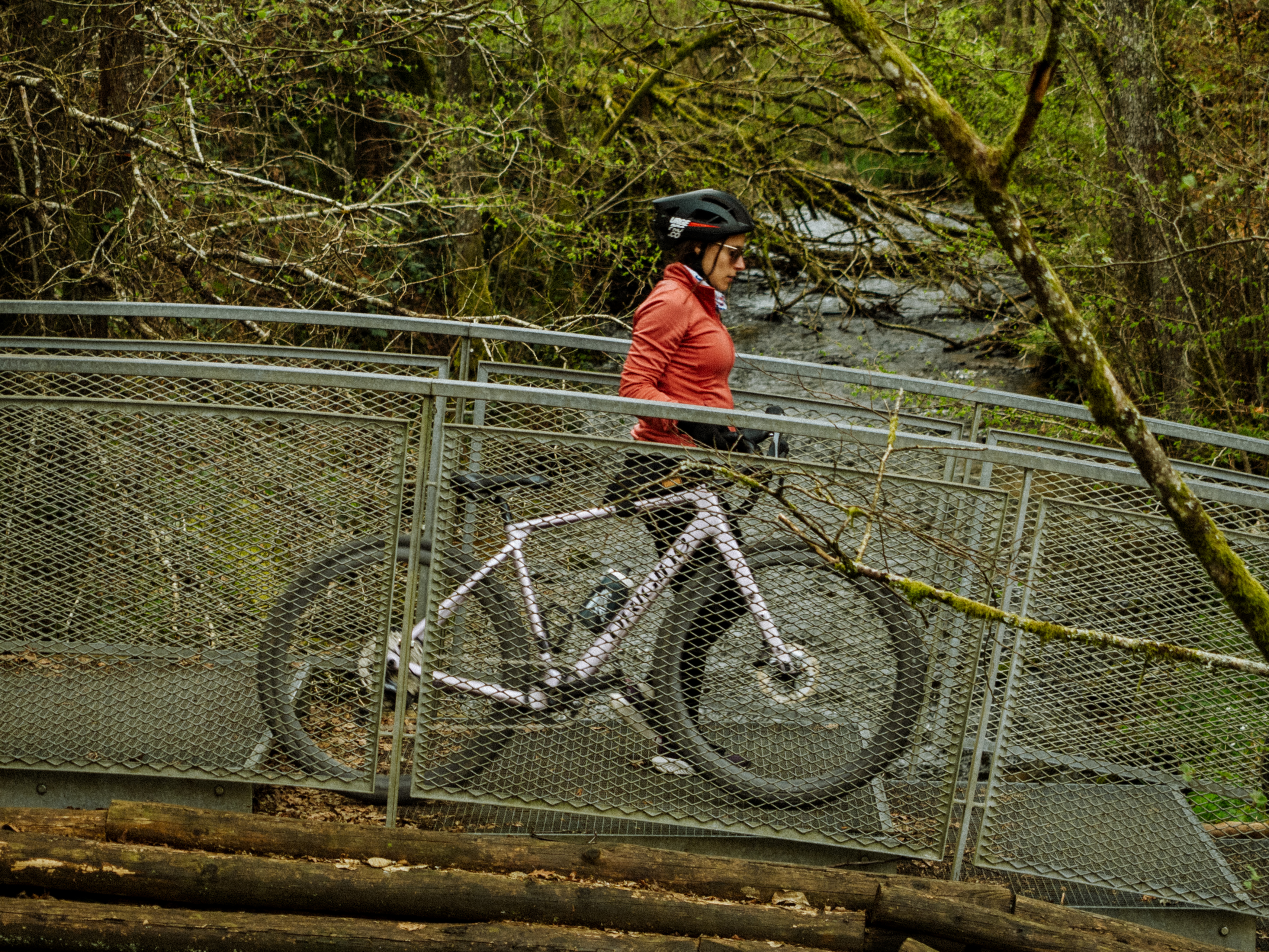 une femme marchant avec un vélo sur un pont 