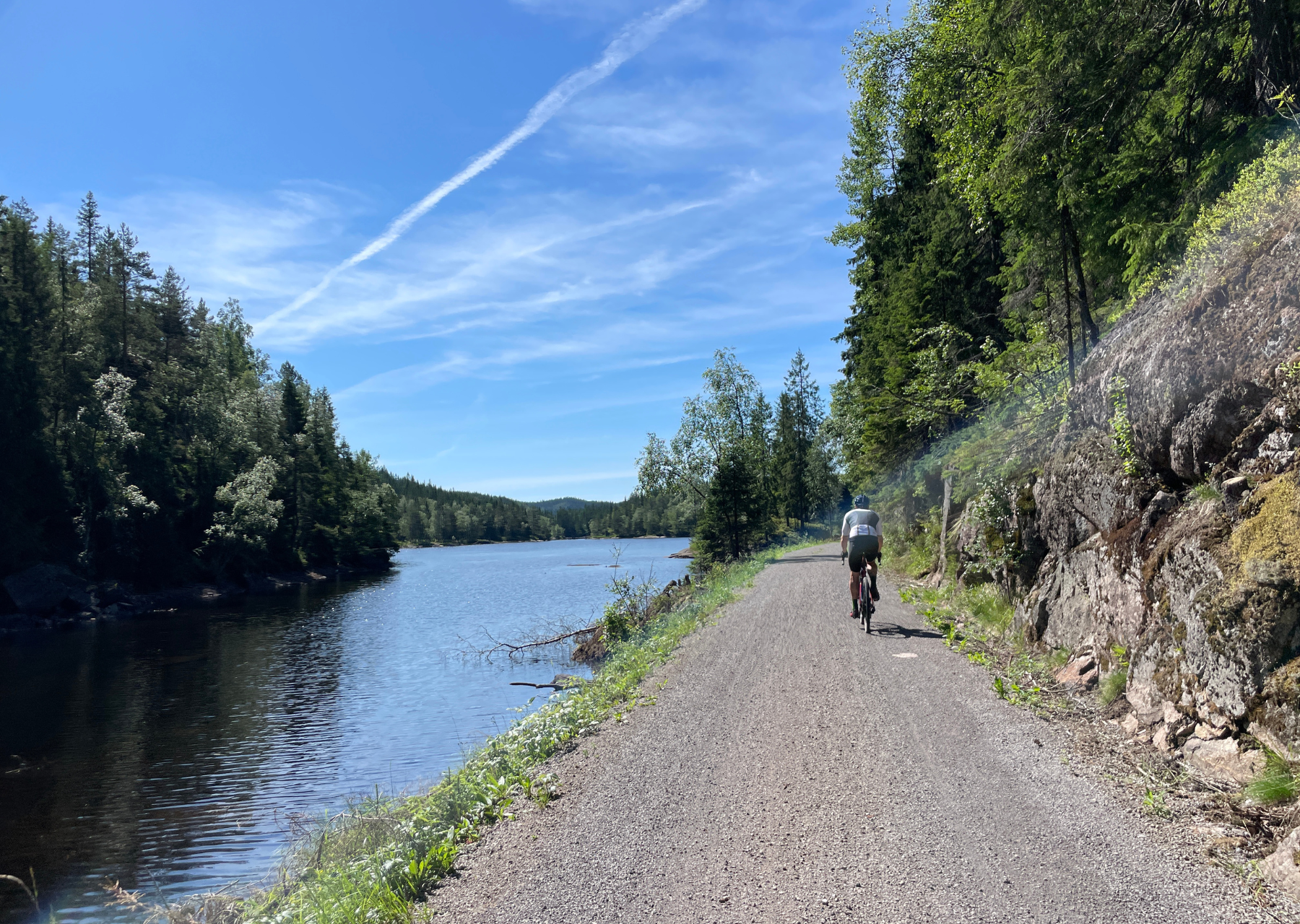 Cycliste sur une voie verte longeant un lac norvégien