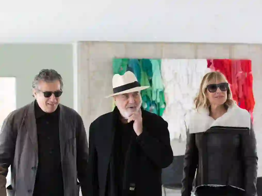 Giorgio Spanu, Michelangelo Pistoletto, and Nancy Olnick stand in front of the artist's 'Stracci italiani', 2007 installation found inside Magazzino's lobby
