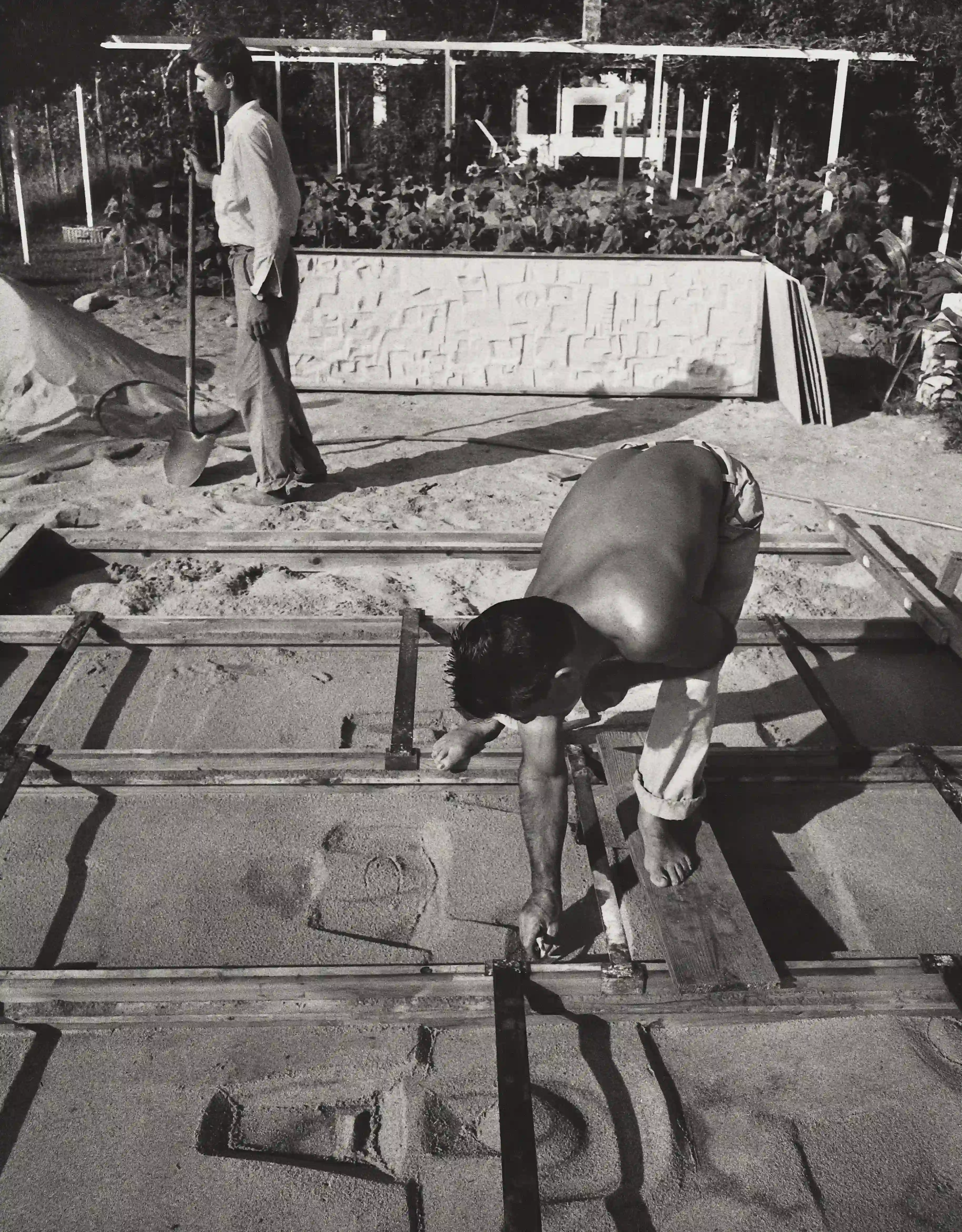 The artist Constantino Nivola, foreground, creating a sculptural relief by using a sand-casting method in 1957.