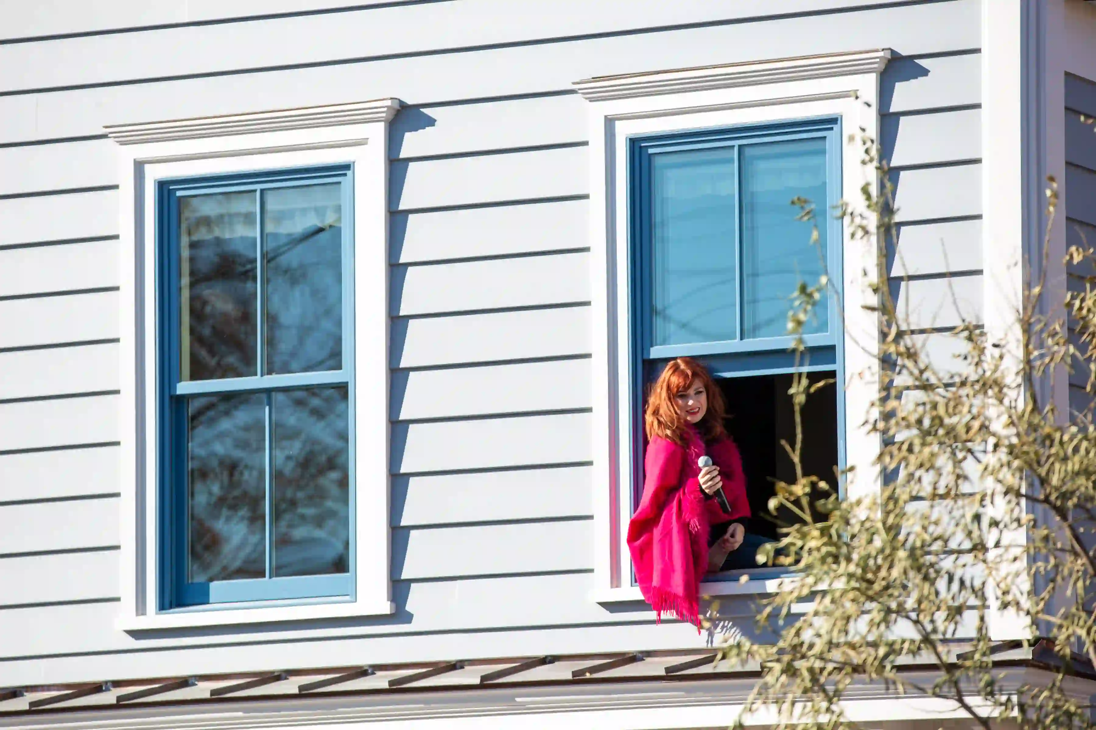 Singer performing outside of a window at the Marinella Senatore and The School of Narrative Dance Performance event, 2019